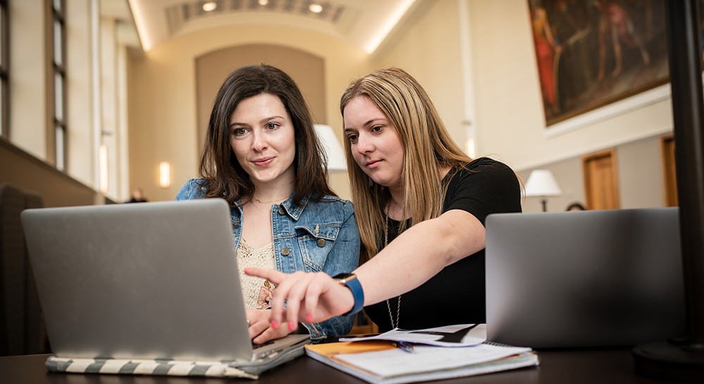 Graduate students working together in the library